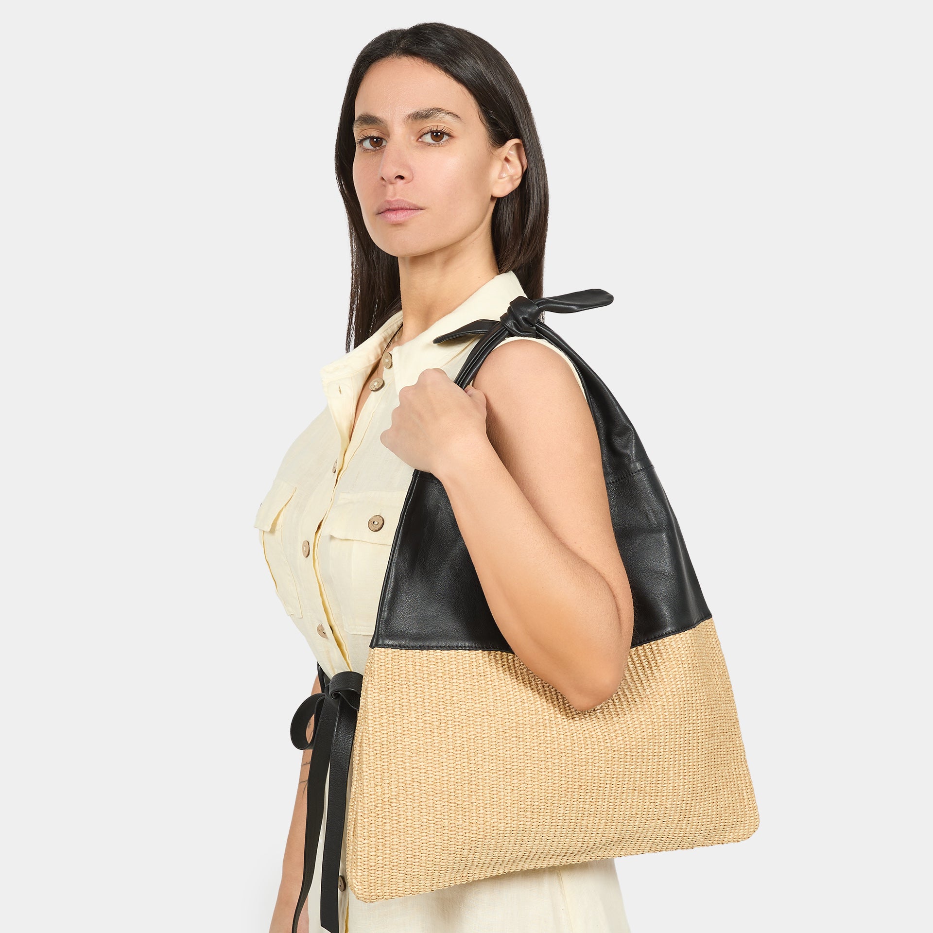 Borsa Arron in pelle nera e rafia naturale con fiocco a spalla