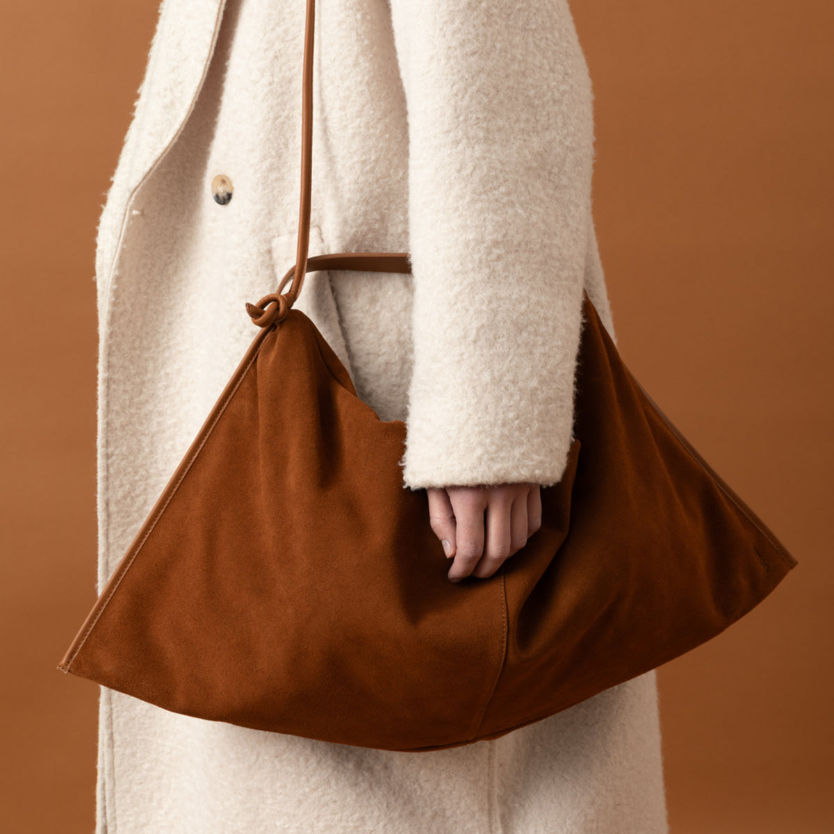 borsa destrutturata a tracolla indossata a spalla in camoscio cognac cammello design contemporaneo minimalista Arron Made in Italy