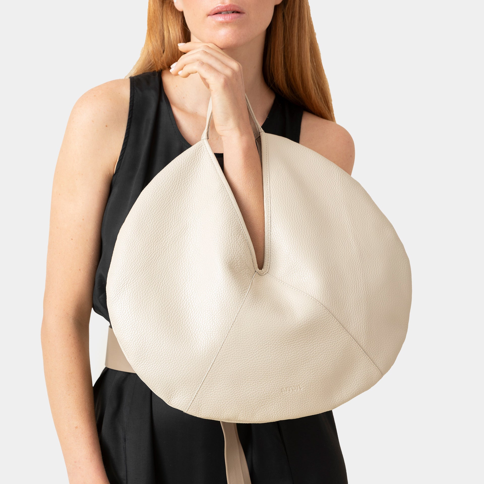 borsa rotonda NOA del brand ARRON in pelle martellata latte avena