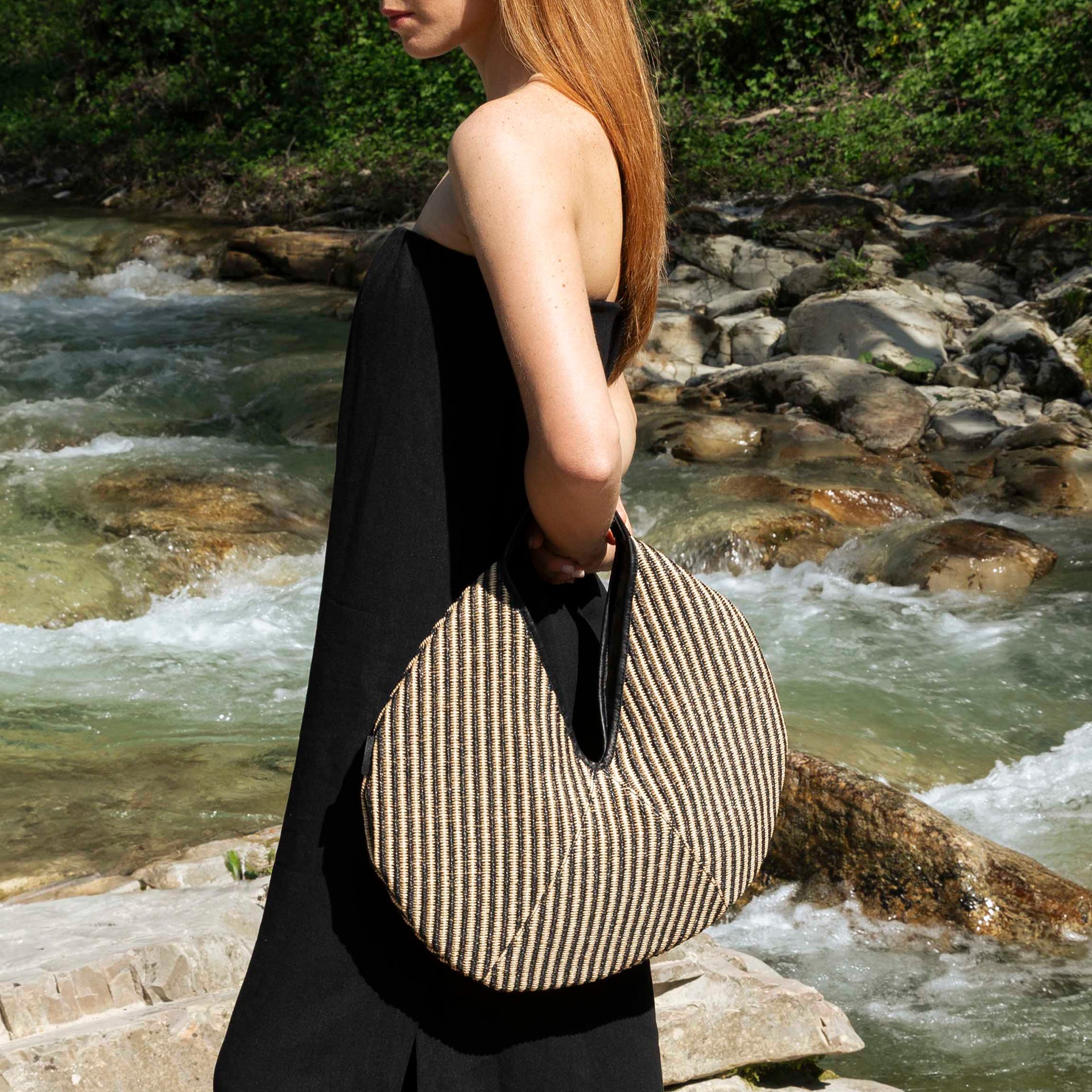borsa rotonda NOA del brand ARRON in rafia rigata e pelle nera