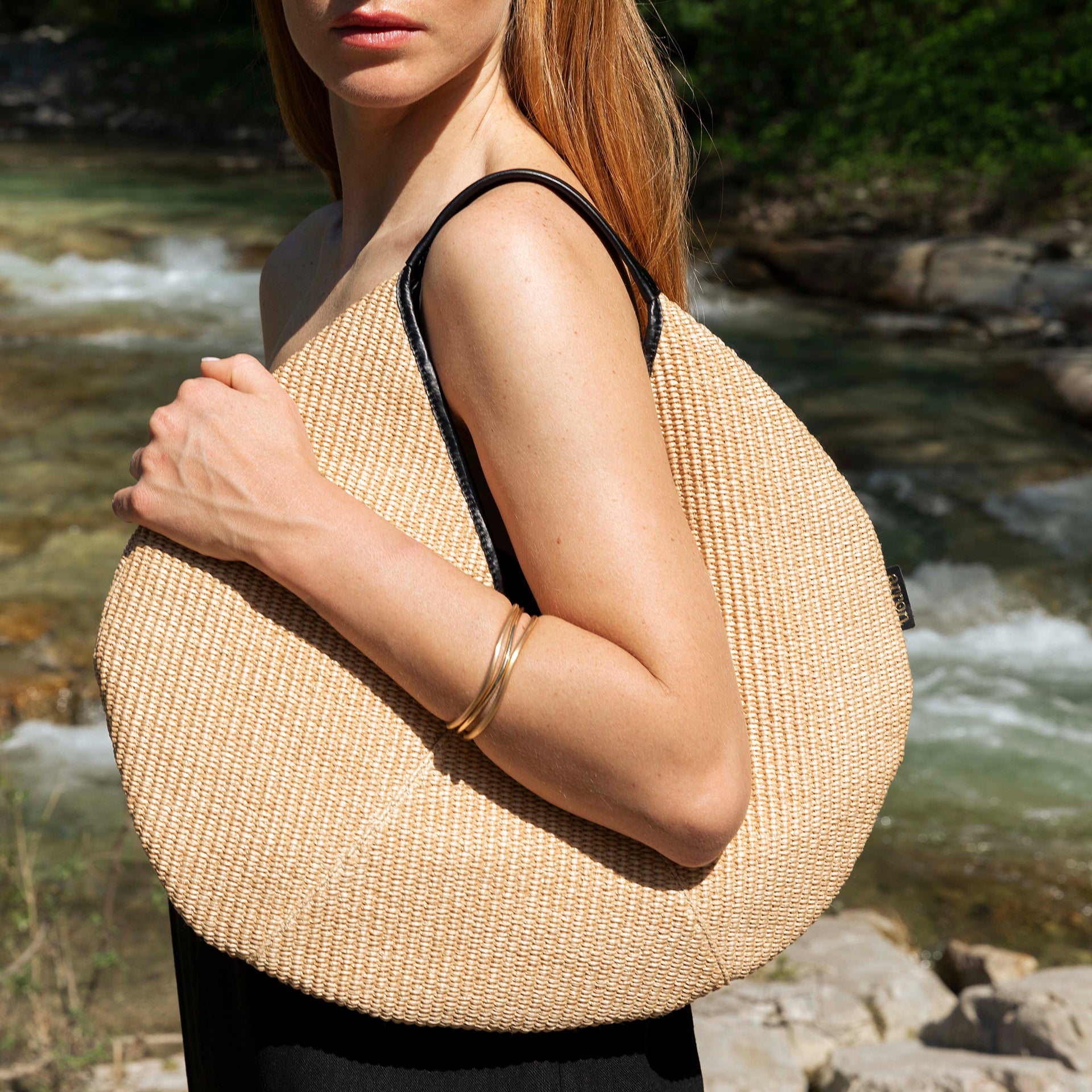 borsa rotonda NOA del brand ARRON in rafia ecrù e pelle nera