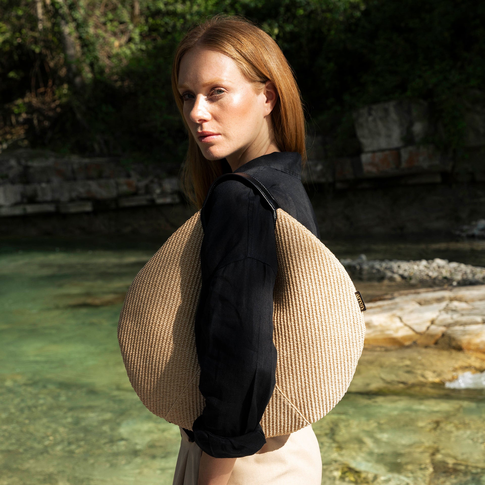 borsa rotonda NOA del brand ARRON in rafia ecrù e pelle nera