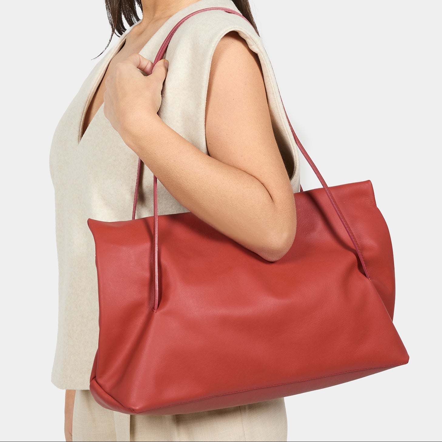 borsa baguette indossata a spalla Arron in morbida nappa color mattone con cerniera zip