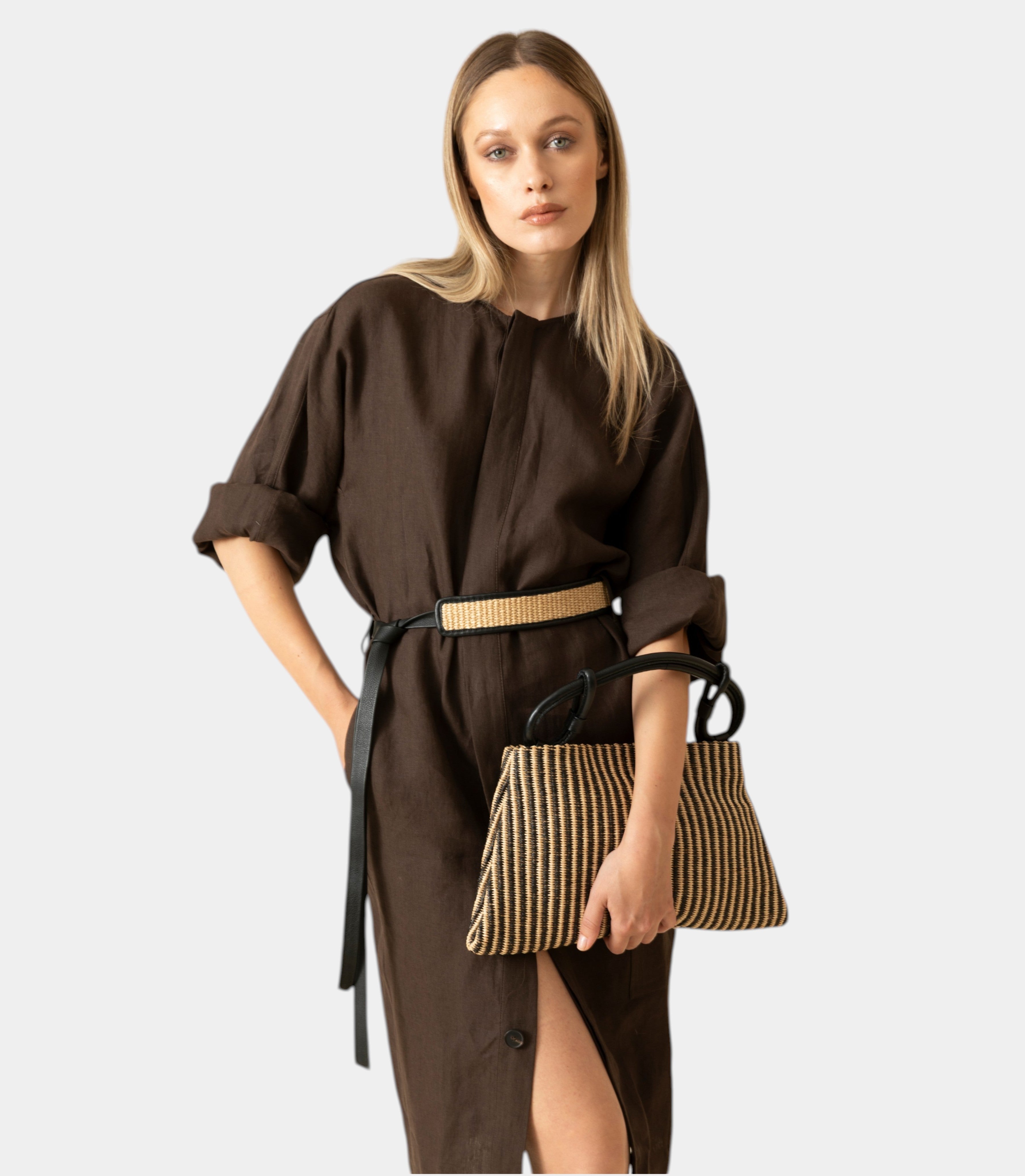 borsa Arron in rafia rigata ecrù e pelle nera con manico a nodo e tracolla indossata a mano