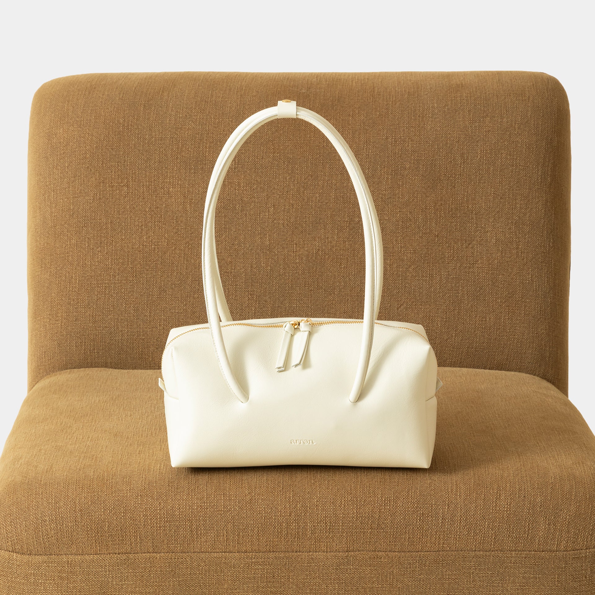 Carol borsa Made in Italy in pelle burro scultorea grafica modello east west con manico di design brand Arron vista frontale lifestyle ambientata