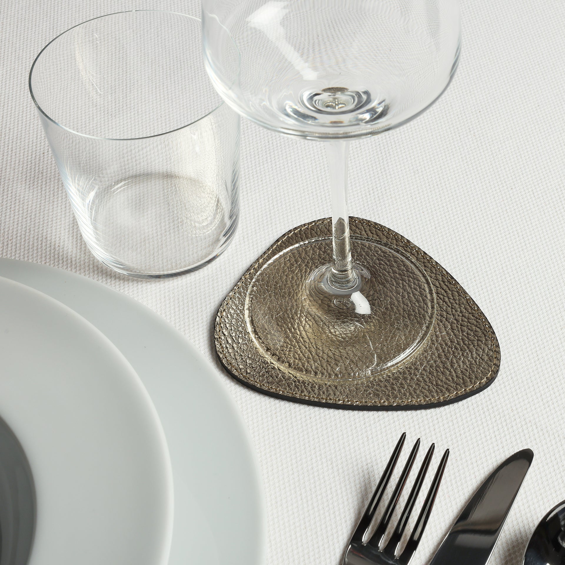 tavola delle feste con sottobicchiere droppy in pelle dorata Arron Made in Italy idea regalo natale tavola capodanno
